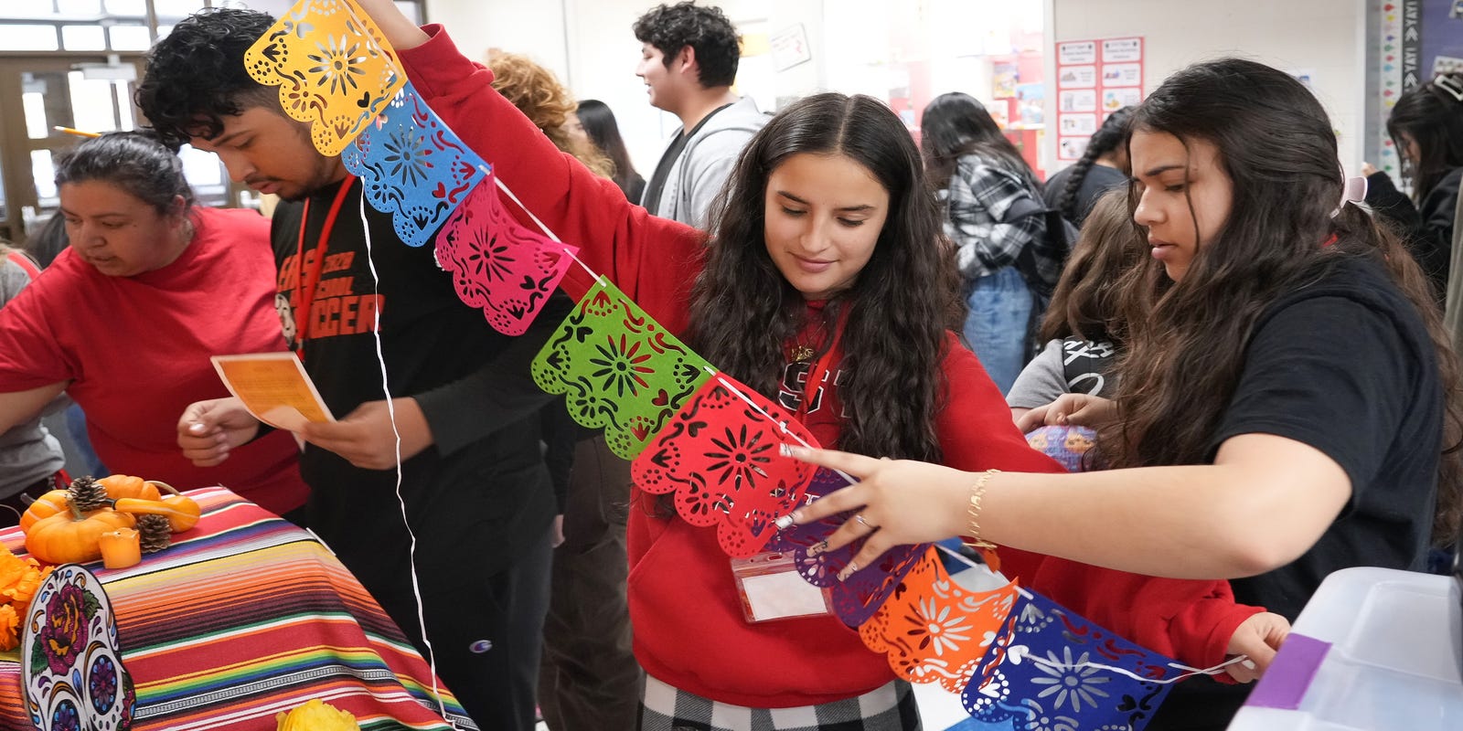 DMPS_WorldLang's tweet card. Students from Des Moines East High helped elementary students from Capitol View build and decorate an ofrenda on Tuesday ahead of Dia de los Muertos.