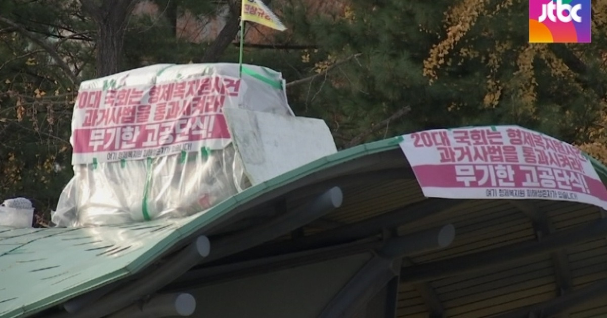 kor119's tweet card. [앵커] 정치인들의 단식은 주목을 받지만 그렇지 못한 단식도 있습니다. 형제복지원 생존자 최승우 씨의 이야기입니다. 국회의사당역 6번 출구 지붕 위에서, 최씨는 21일째 진상규명을 위한 과거사법 처리를 촉구하는 단식농성을 이어가고 있습니다. 임소라 기자입니다. [기자] 2년간 국회 앞에서 농성을 벌이던 최승우 씨는 지난 6일, 5m 지붕 위로 올라갔습니다.