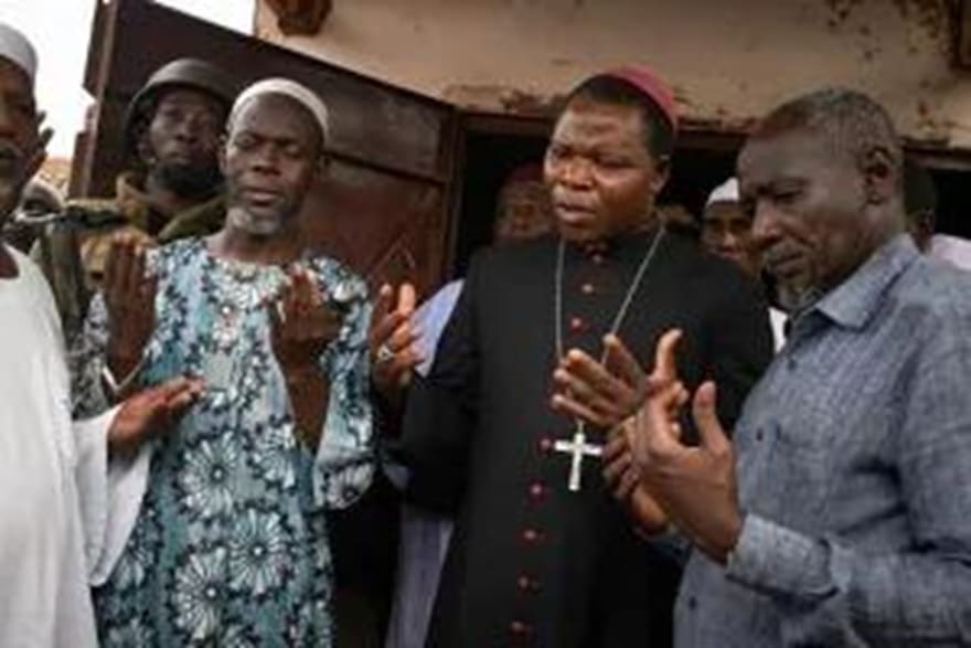 iProudChristian's tweet card. In the bustling market square of Jos, a woman named Miriam arranges bright red tomatoes on a wooden table. Beside her, Yusuf stacks peppers and onions. Thei ...