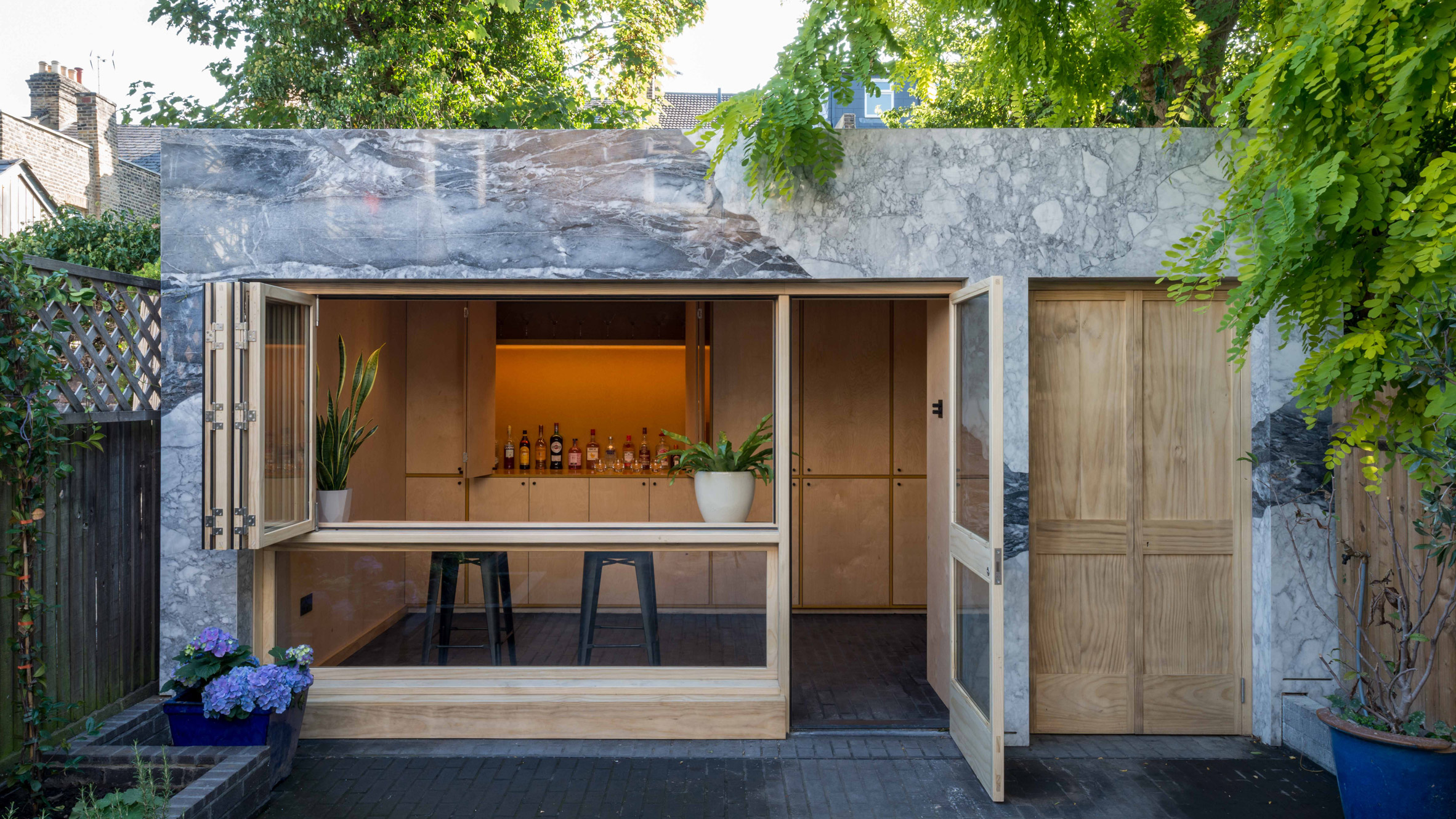 dezeen's tweet card. Alexander Owen Architecture has added a marble-clad extension to this Victorian mid-terrace to accommodate a home office and a bar.