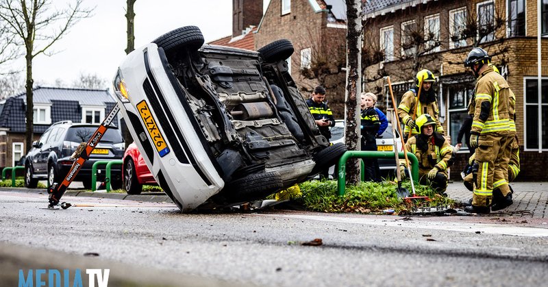 Auto belandt op zijn kant na aanrijding tegen boom