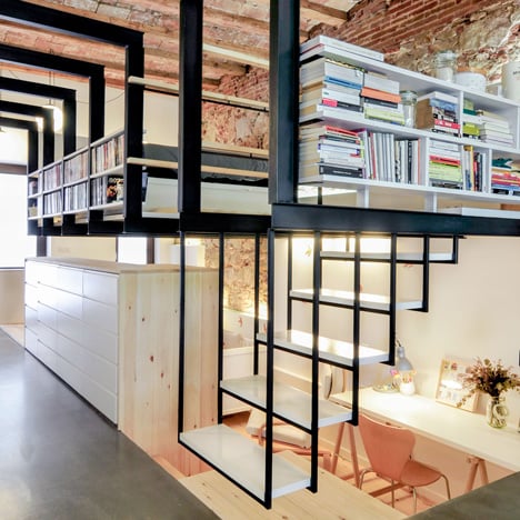 dezeen's tweet card. Renovation of an apartment in Barcelona by Carles Enrich with a mezzanine supported on black metal I-beams and a combined staircase and bookshelf.