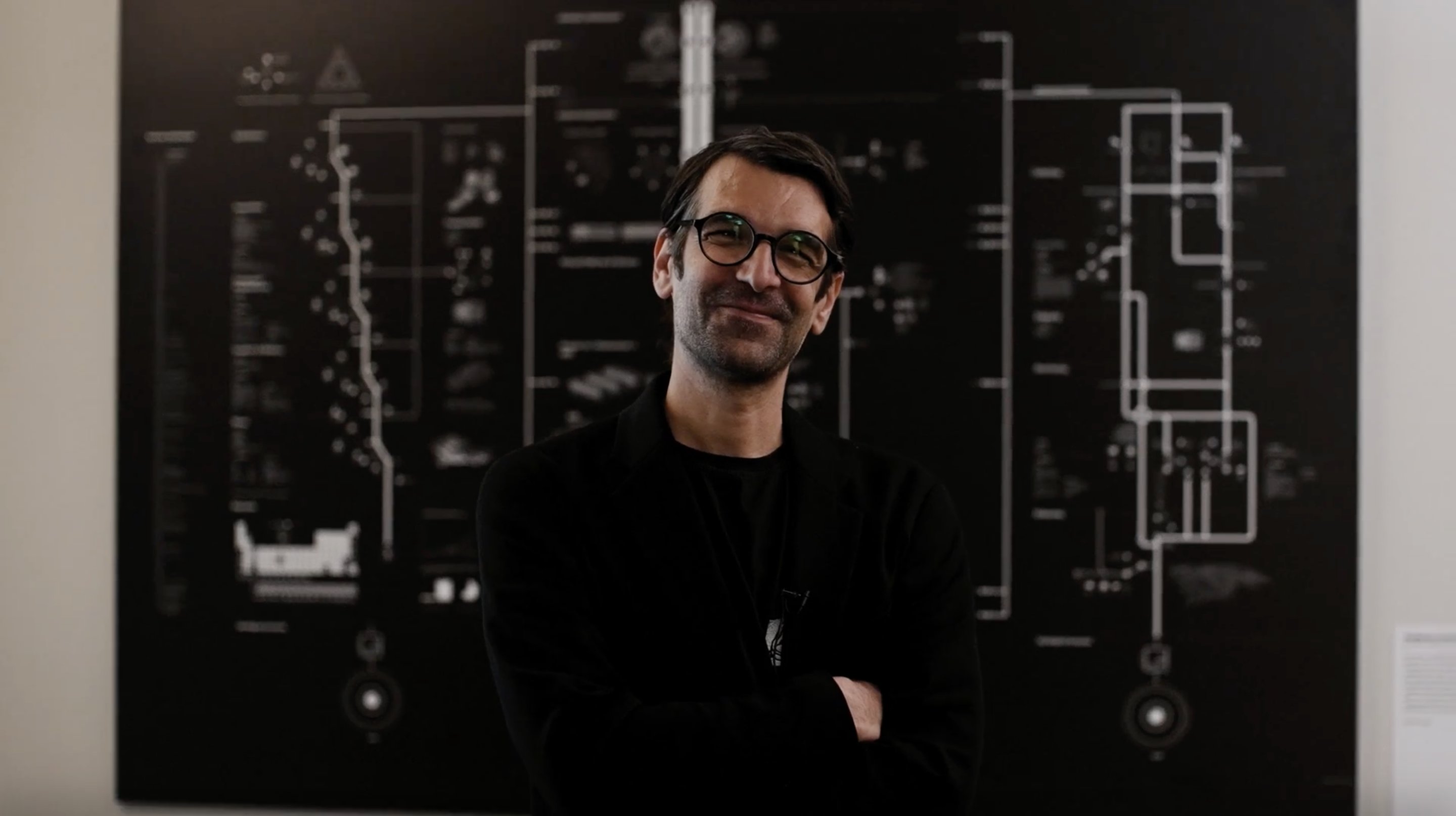 public_spaces's tweet card. An abundance of lines, arrows, symbols, process diagrams and small descriptions entangled in one large network is displayed on giant black-and-white screens. These maps are the result of the cartog...