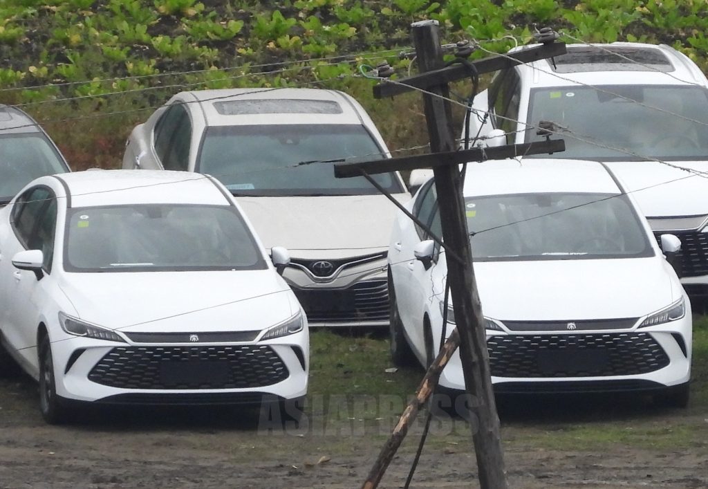 API_official's tweet card. 今年9月、アジアプレスの取材チームは中国吉林省長白県で、これまで見たことのない光景を目撃した。鴨緑江の対岸の北朝鮮両江道（リャンガンド）恵山（ヘサン）市内のいたる所に、百数十台の高級乗用車や大型トラッ