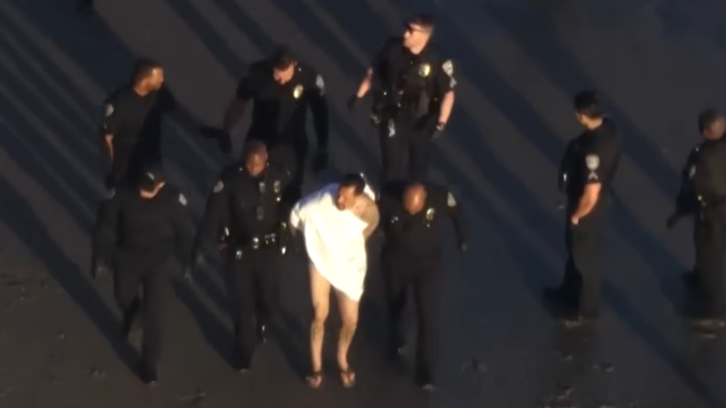 PIOPodcast's tweet card. After crashing the vehicle, the suspect fled on foot; officers found him at the beach, naked, and took him into custody