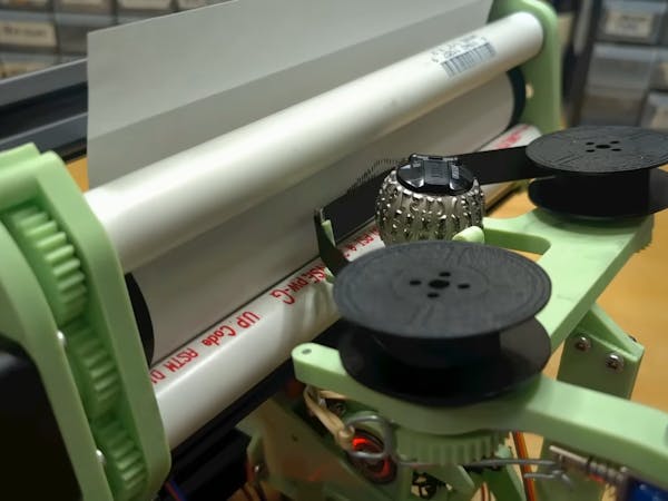 Hacksterio's tweet card. Unnecessary Automation used an IBM Selectric “golf ball” to build this crazy machine that automatically produces ASCII art-style prints.