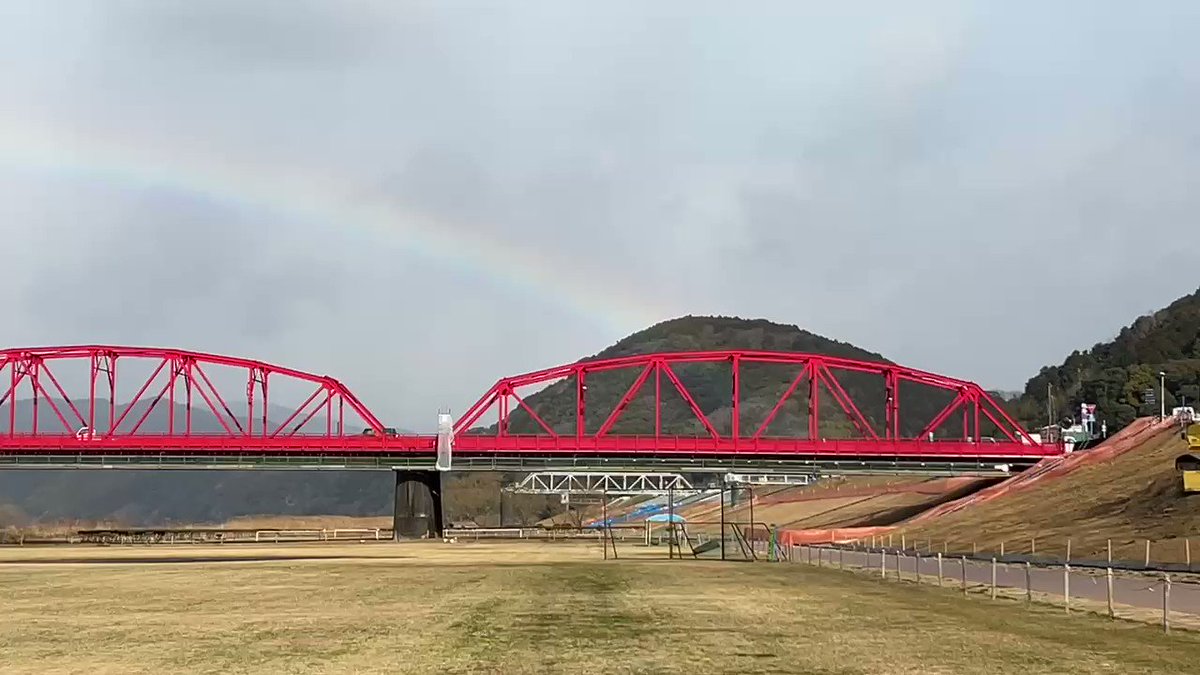 虹の四万十川。日曜日の朝、赤鉄橋（四万十市）の上に色鮮やかな虹。天空に向かって七色の道が続く。虹の根元の入田の柳林で黄色い菜の花畑が出番を待つ。大きな虹の橋を渡って春がやって来る。