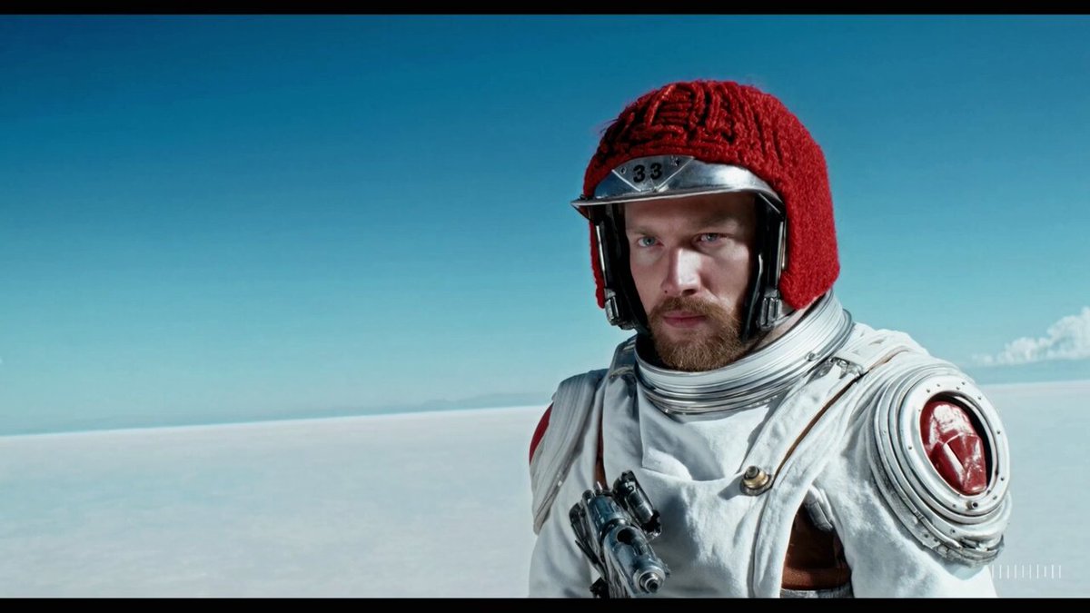 A movie trailer featuring the adventures of the 30 year old space man wearing a red wool knitted motorcycle helmet, blue sky, salt desert, cinematic style, shot on 35mm film, vivid colors.