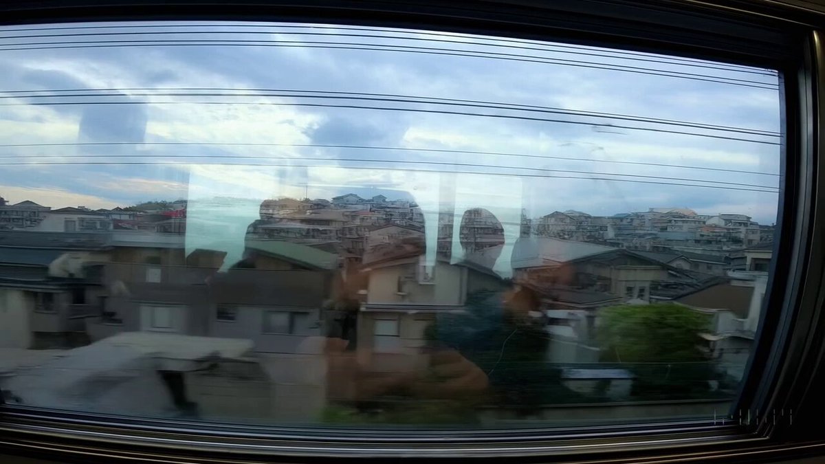 Reflections in the window of a train traveling through the Tokyo suburbs.