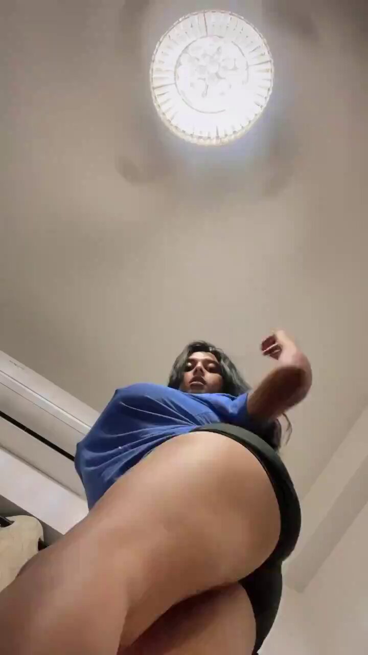 A woman striking a seductive pose in a private setting bathed in soft light