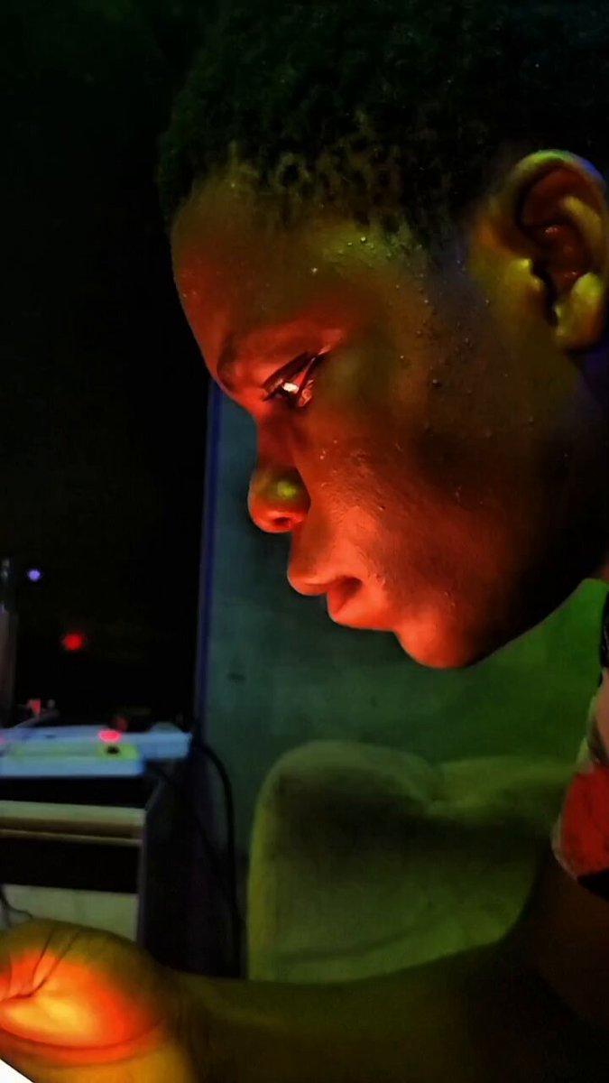 Kabeerdefi using Base App in a dimly lit room with a green and red hue