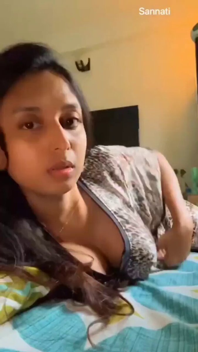 A woman in a towel playfully dancing near a monument drawing curious glances