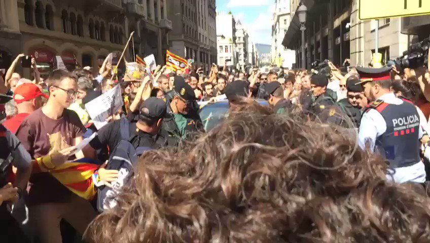 Los manifestantes, sentados en el suelo, para intentar barrer el paso al coche donde iba detenido Xavi Puig, responsable de Exteriores.