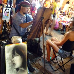 KengoCreator's tweet image. タイ（チェンマイ）のサンデーマーケットでのとある似顔絵画家さん「描く」というその一念が全身から伝わってくる！！本気でやるとは何かを教えていただいた。