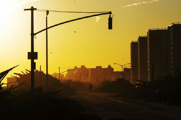 A man walks down Shore Front Parkway in the Rockaways surrounded by debris. Sums up how bad the damage is. #Sandy