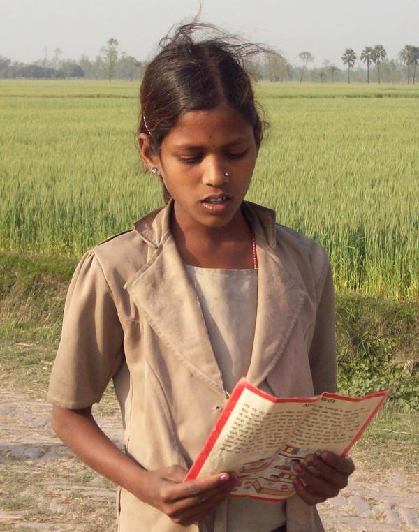 prathambooks's tweet image. Here&apos;s a picture of a girl who reading a book while she was cattle-grazing  #readingonthego #PBcards #PBCards