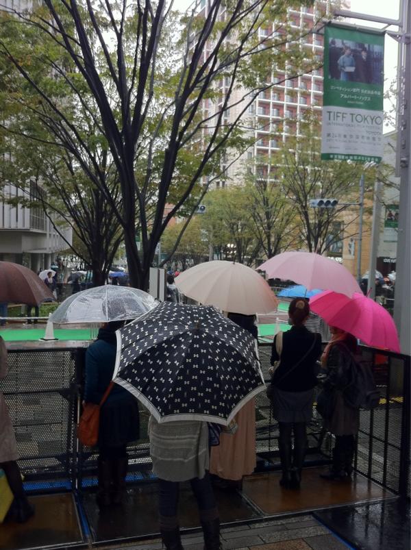 roppongihillsCH's tweet photo. パラパラと雨の降る中、既に人だかりの出来ているけやき坂。空は明るいのでなんとか天気が持ってくれるでしょうか！？このあと13時半から、グリーンカーペット生中継です！ http://t.co/hvqsxM6A
