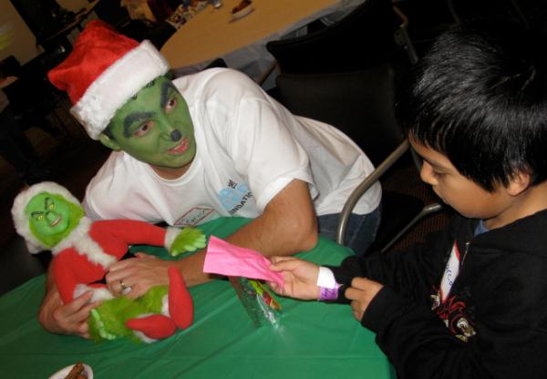 Here is one of our volunteers (and MC) breaking the ice with one of the kids...he is painted as the #Grinch!