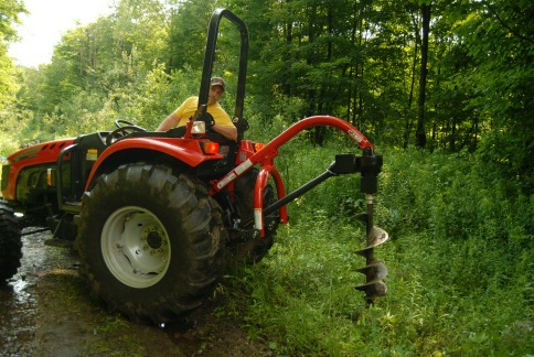 Backing an X10.55 and McCormick by Woods Post Hole Digger in place for a gate project.