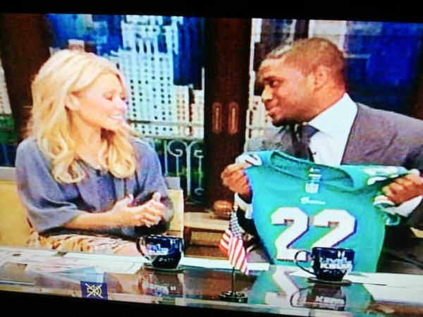 MiamiDolphins's tweet photo. Here's @reggie_bush giving a customized Dolphins jersey to @KellyRipa. http://t.co/nOaTOIFf