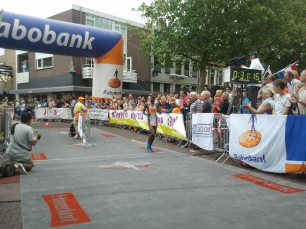 De winnaar 10k Coevorder Grachtenloop komt over de finishmat.