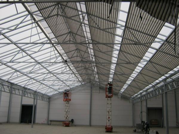 Nieuwbouw; De vloer is gelegd en nu gaat het schermdoek erin. Goed te zien dat er een heel stuk winkelruimte bij komt.