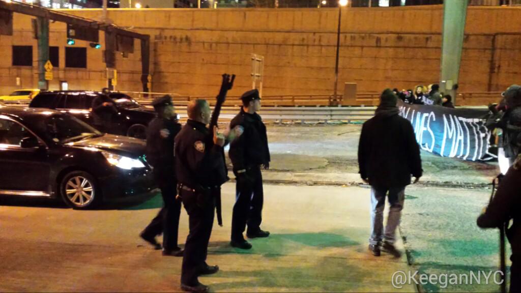 KeeganNYC's tweet photo. That is a fucking shot gun drawn and cocked on a peaceful protest. 
#ShutItDown For #BlackLivesMatter http://t.co/ZzFj0S7fLk