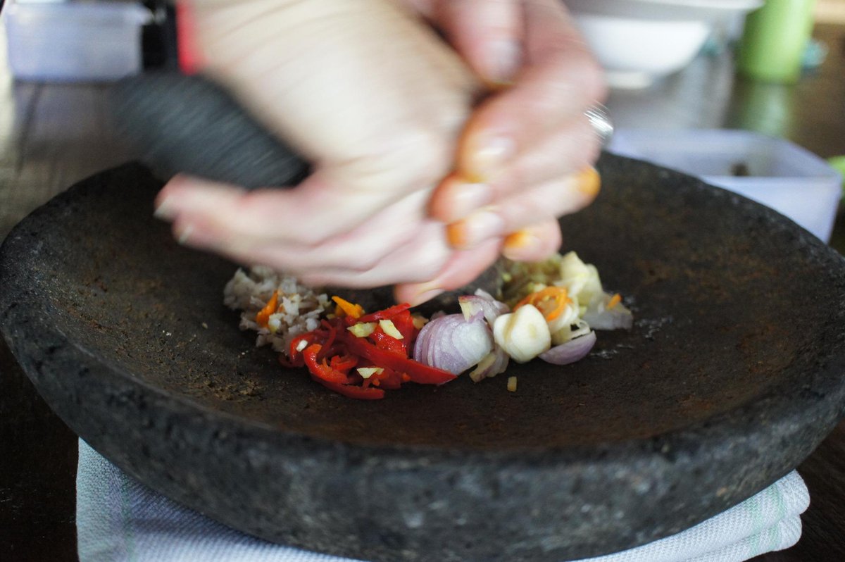 Här lär vi oss tillreda den traditionella kryddblandningen Bumbu Bali, precis som förr, i en mortel av lavasten.