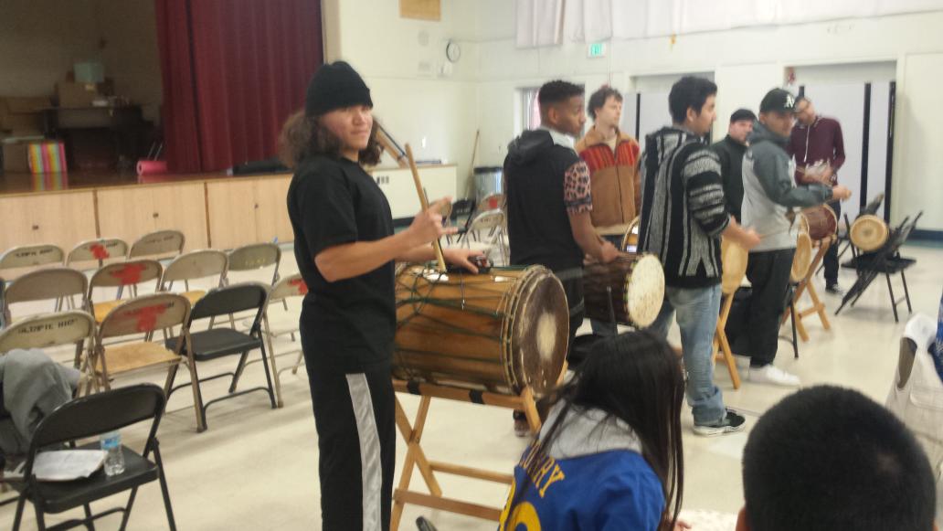 Students learn to play and perform African drums to build community and recognize diversity.