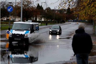 More than a dozen cars have been trapped between two landslips as heavy rain caused flooding and travel disruption.