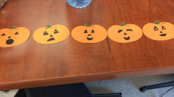 Five little pumpkins sitting a a gate!
