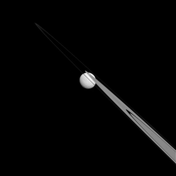 Like a drop of dew hanging on a leaf, the moon Tethys appears to be stuck to Saturn's rings from this perspective.