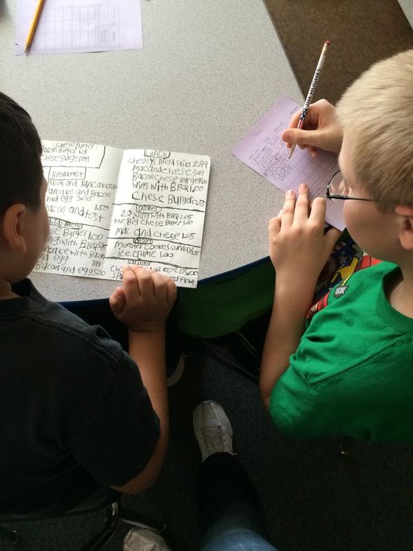 The students are playing restaurant using menus they created to practice adding and subtracting.