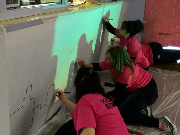 HuddleUpChicago's tweet photo. Chicago skyline being painted at the reception desk #iammagenta #HuddleUpChicago2014 @DaWestTeam @TMobile http://t.co/VyiW6sYzrO