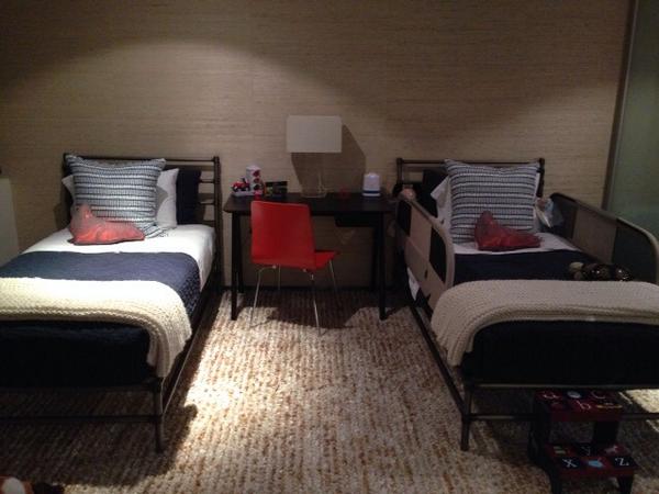 A well designed little boy room with a pair of 24" square pillows in Train Tracks on Mandarin Oyster in Indigo Blue.