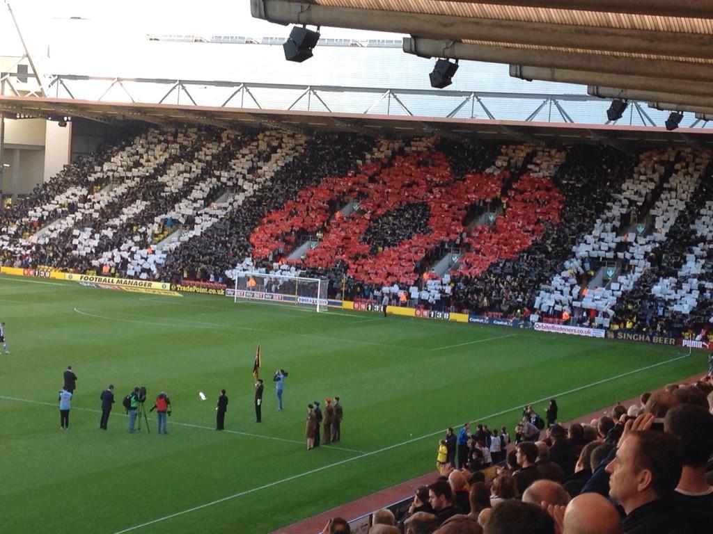 A genuinely poignant moment here at #watfordfc as the Rookery lifts aloft the poppy display #LestWeForget