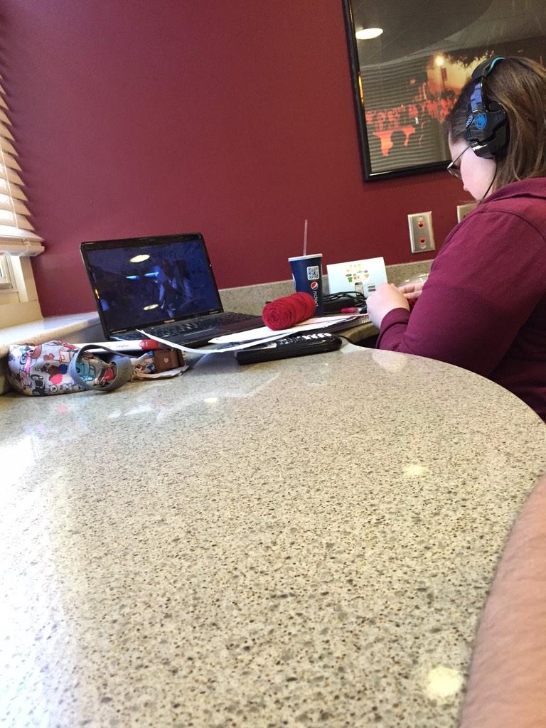 This girl sitting up in Lloyd watching tv, doing math homework and knitting