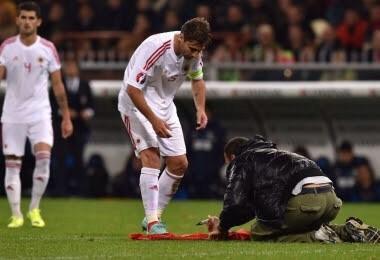 LazioWatch's tweet photo. Lorik Cana signing a shirt of a pitch invader last night during Italy V Albania http://t.co/3w1uRjhFfp