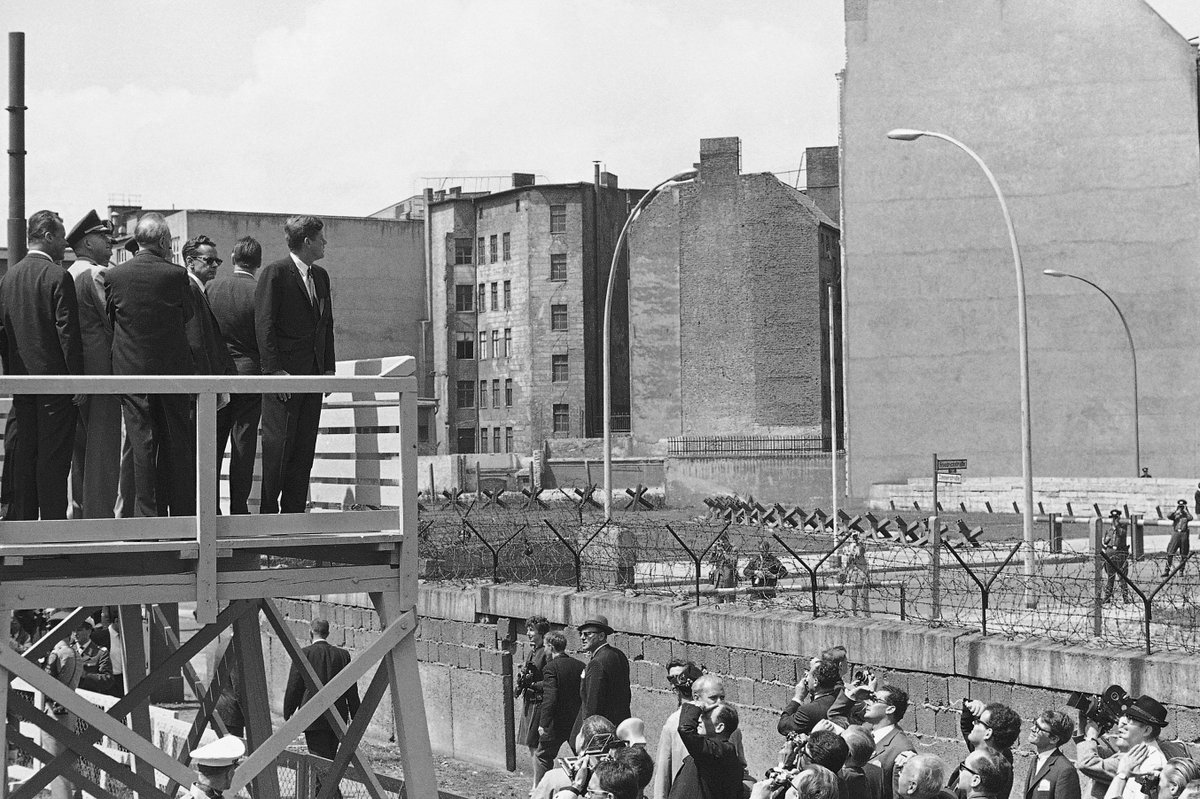 RealTimeJFK's tweet image. From June 26, 1963: Kennedy standing on an observation platform looking into East Berlin across the Berlin Wall.
