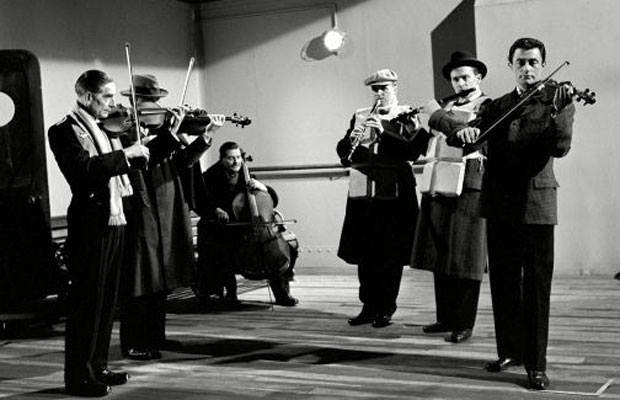 On the real Titanic, the band actually did stay on the ship, playing music as it went down. They all died.