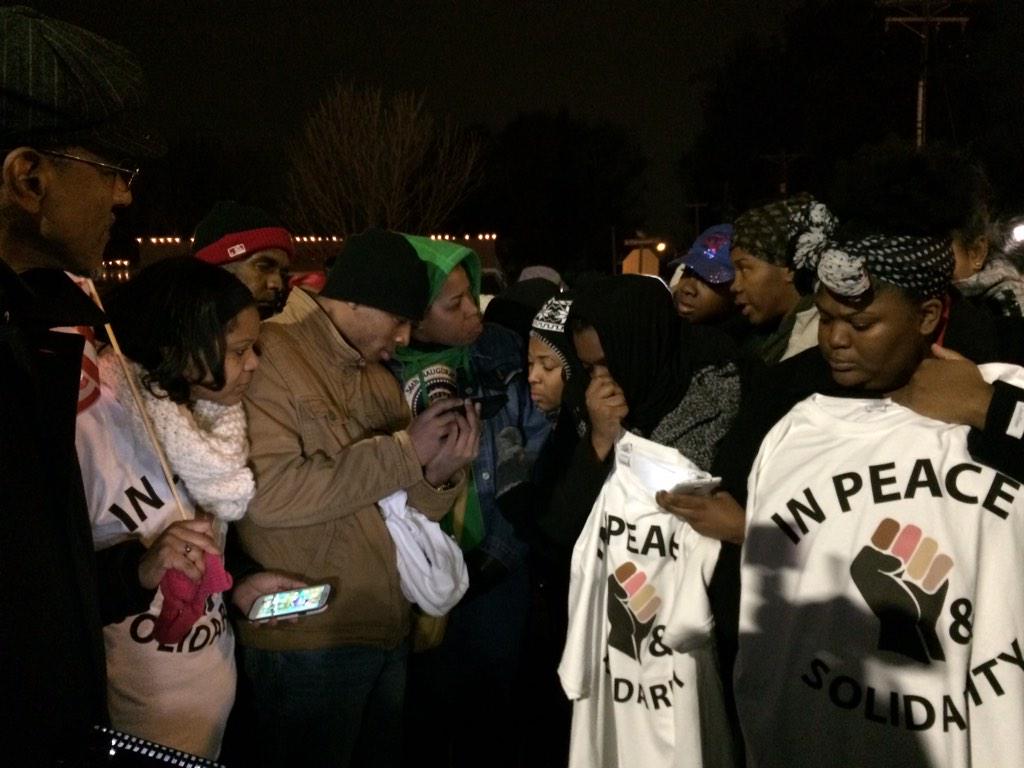 Protesters listening to news of #GrandJuryDecision on cell phones. Tense in #Ferguson