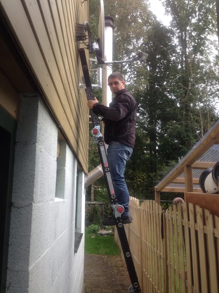 Schotelsysteem installeren op de buitenplaats. De ladder kan net tussen de huisjes staan!