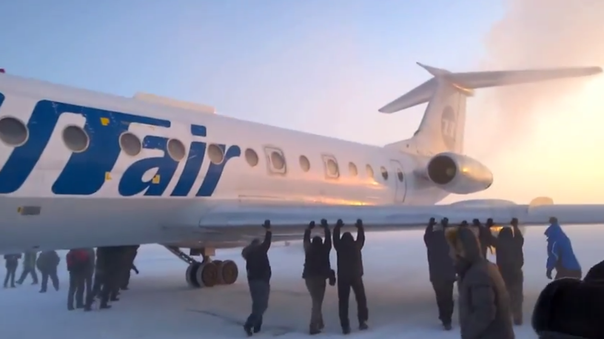 mashable's tweet photo. Passengers push plane from ice after temperatures plunge in Russia. Watch: http://t.co/kBX8kCzph7 http://t.co/p3aH5emF1c