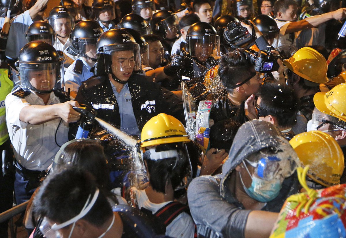 YahooNews's tweet image. PHOTOS: Police officers use pepper spray to stop pro-democracy protesters in Hong Kong. yhoo.it/1rJHSGj #photo