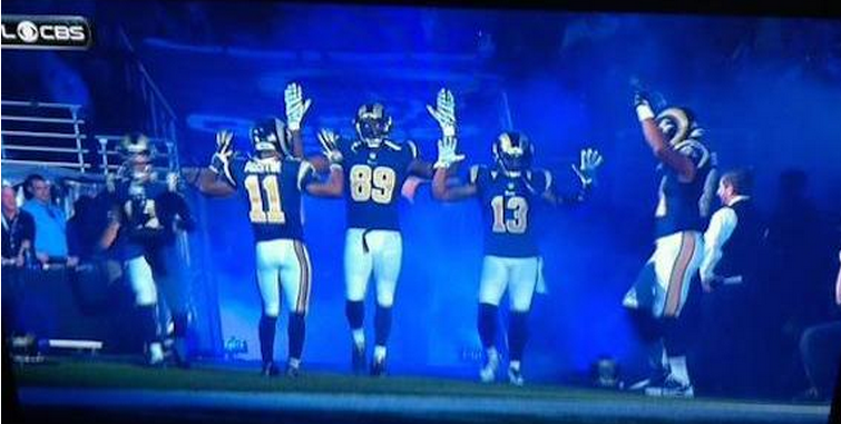 BleacherReport's tweet photo. VIDEO: Rams players do the "hands up, don't shoot” pose before game vs. Raiders http://t.co/6SrOlSQoJm #Ferguson http://t.co/JQ5KkFU6vL