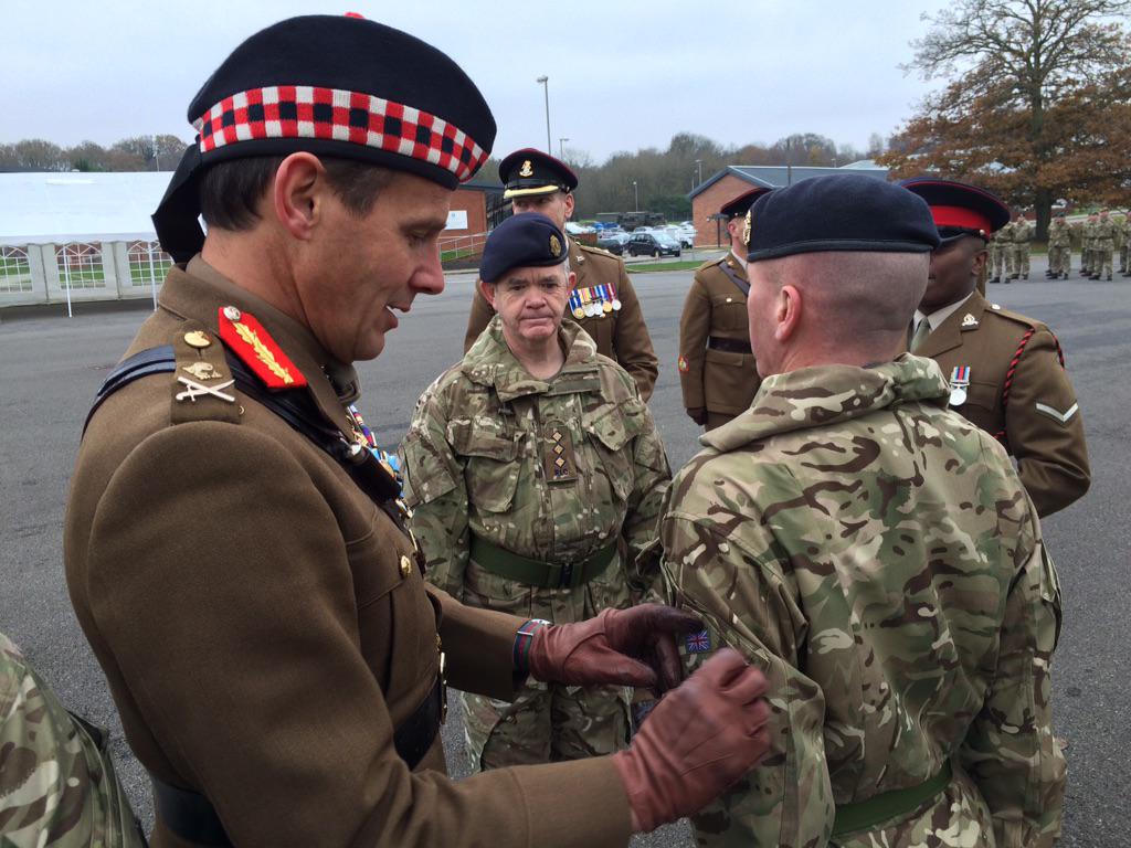 PHOTO: Maj Gen James Cowan of <a href="/3rdUKDivision/">The Iron Division</a> presents 'Blackadder' flashes to reservists joining 101 Logistic Brigade