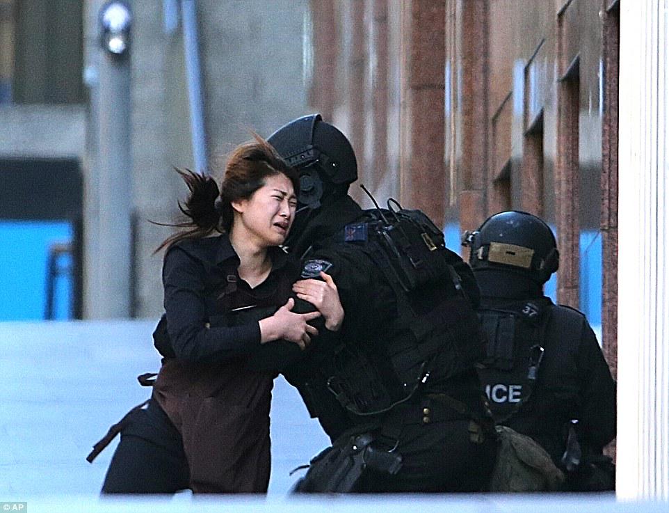 DailyMailAU's tweet photo. Hostage falls into policeman’s arms after being released http://t.co/csL4lAPffR #SydneySiege http://t.co/jfF7hivmol