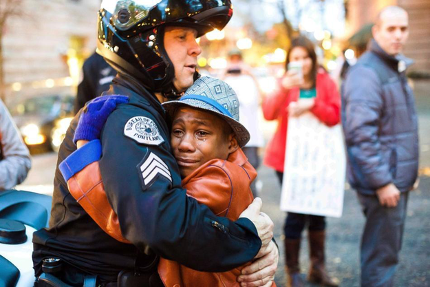 UberFacts's tweet photo. This photo of a 12-year-old boy hugging a police officer at a Ferguson protest in Oregon is going viral. http://t.co/5DyiIVDst9