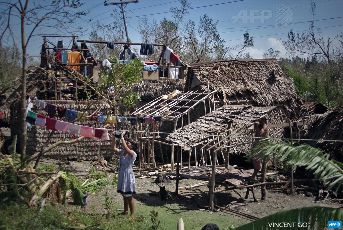 fgeffardAFP's tweet photo. #Hagupit - A resident hangs laundry in front of destroyed houses in Borongan, Philippines by Vincent Go #AFP http://t.co/8M9PDaSofY