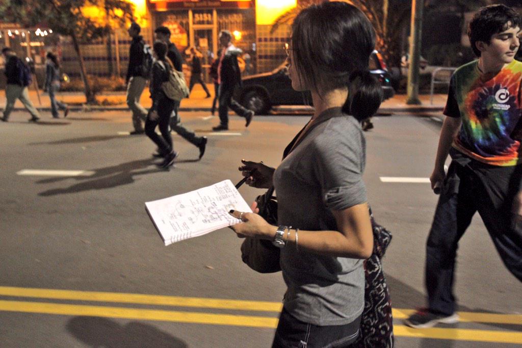 CAGisMe's tweet photo. Cal student Kristina Vu studies as she marches down Telegraph Avenue. #BerkeleyProstests #Ferguson #ICantBreathe http://t.co/PVvAeyv9Nk